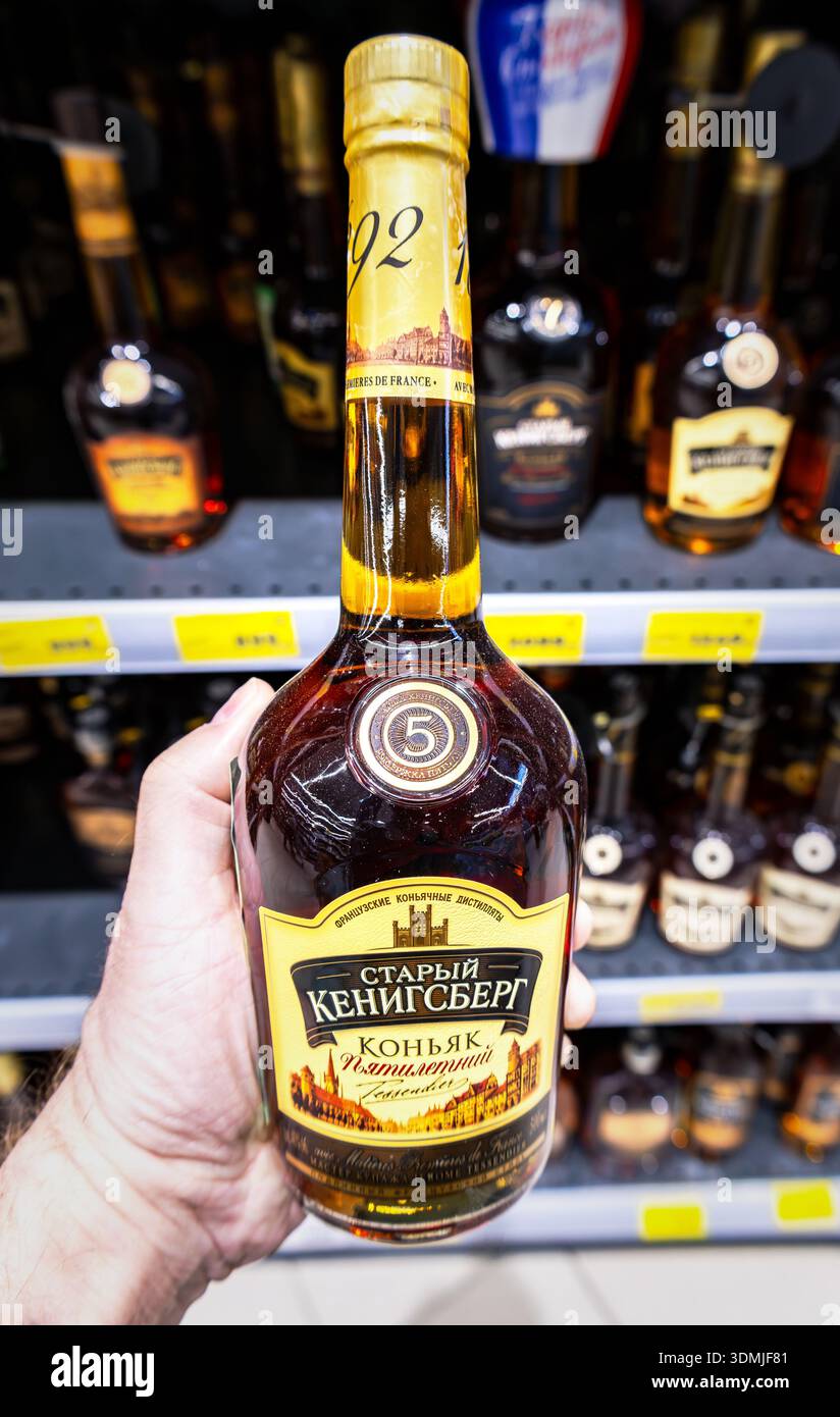 Samara, Russland - 25. Mai 2025: Der alte Kenigsberg 5 Jahre alter Cognac in der Hand in einem Supermarkt. Starke alkoholische Getränke in Flaschen Stockfoto