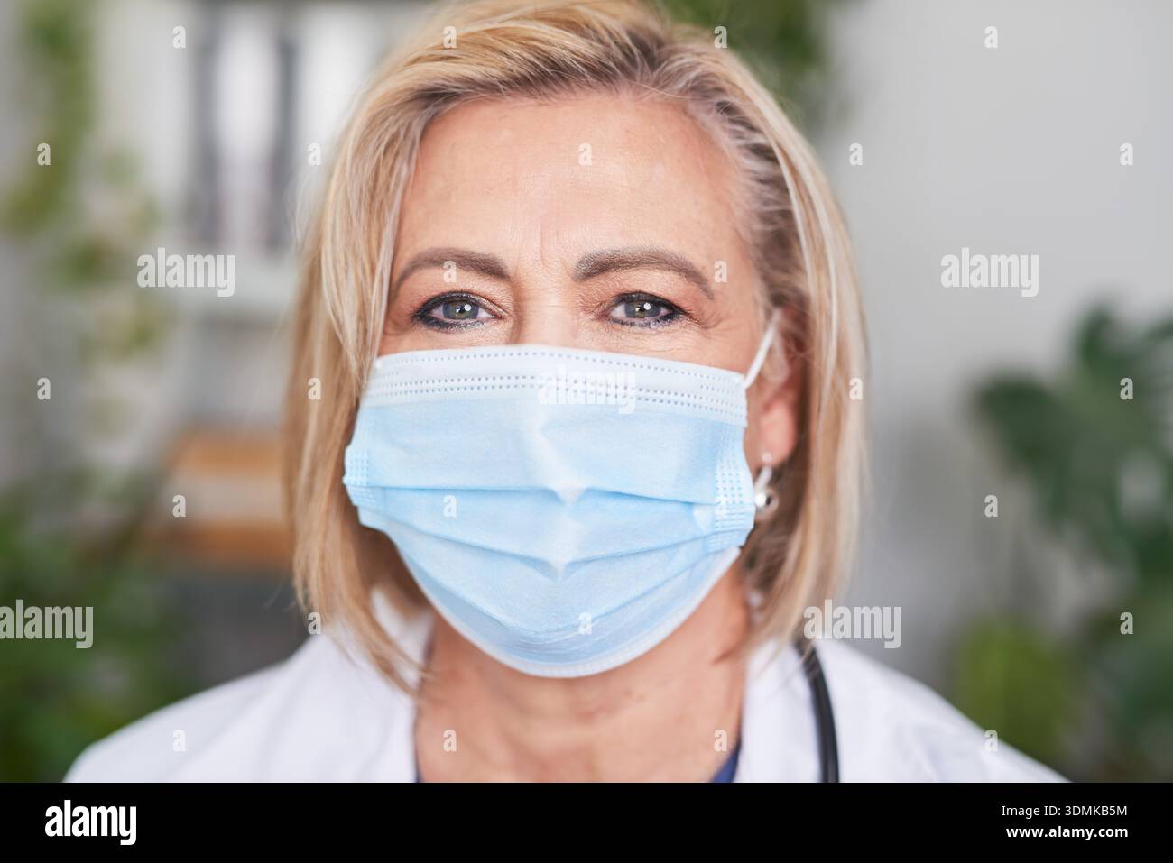 Senior weibliche medizinische Fachkraft, die eine medizinische Gesichtsmaske in einer Outdoor-Umgebung trägt Stockfoto