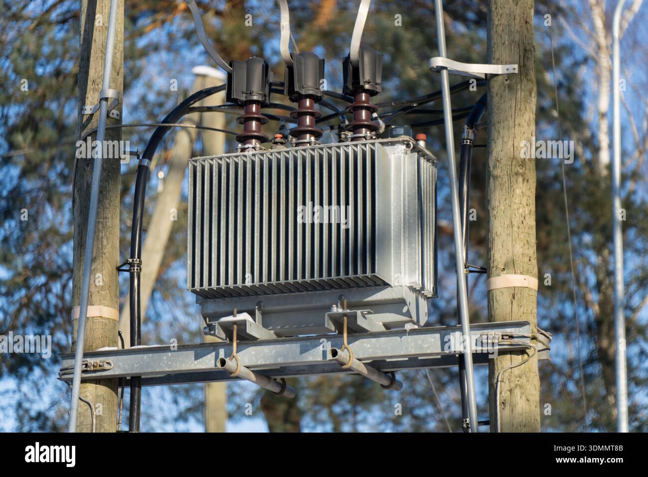 Detailansicht des elektrischen Transformatorkastens am Versorgungsmast, isolierte Steckverbinder und Verkabelung am Metallquerträger, Stromnetzgeräte bei Tageslicht Stockfoto