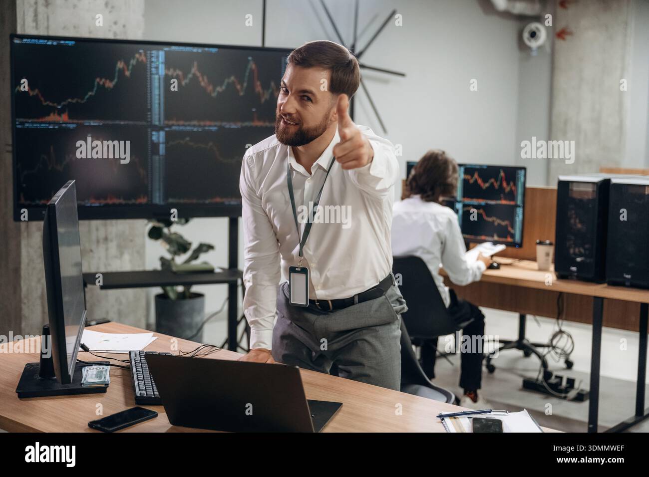 Du machst es toll, mit der Hand auf den Finger zu zeigen. Zwei männliche Austauscharbeiter sind zusammen im Büro. Stockfoto