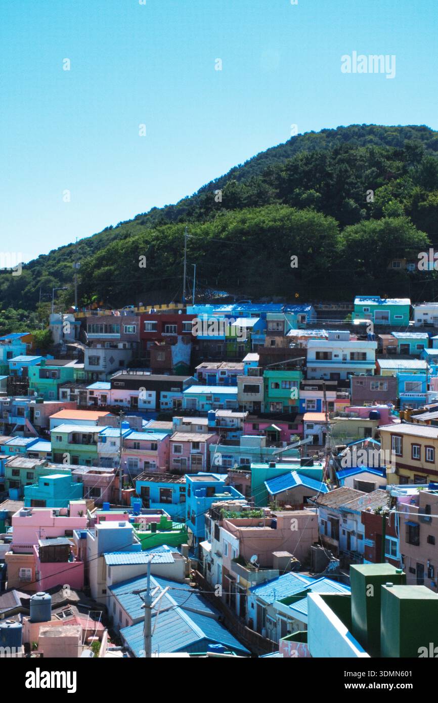 Eine vertikale Hochwinkelaufnahme mit den berühmten bunten Terrassenhäusern des Gamcheon Culture Village unter klarem blauen Himmel. Die lebendige Pastellfarbe Stockfoto