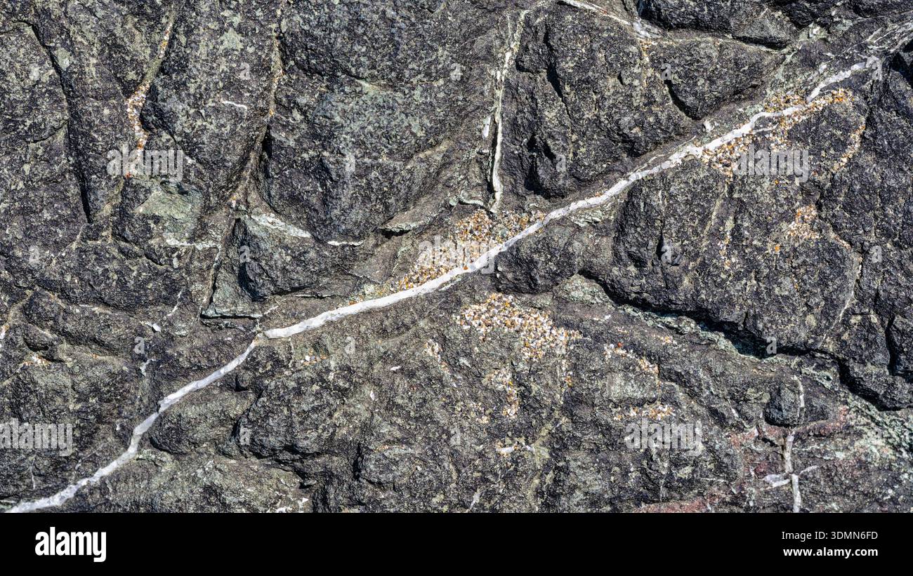 Abstrakte Marmor-Adermuster und Sandkörner auf einer natürlichen Granitoberfläche Stockfoto