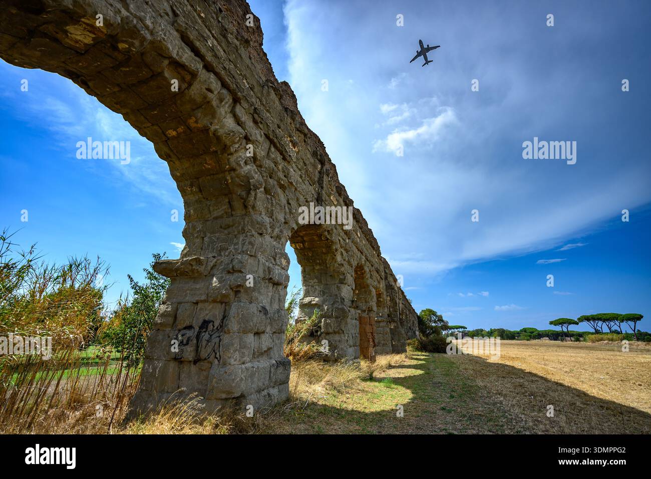 Historische Aquäduktstruktur mit sich wiederholenden Bögen und Mauerwerk im Parco degli Acquedotti Park, Rom. Stockfoto