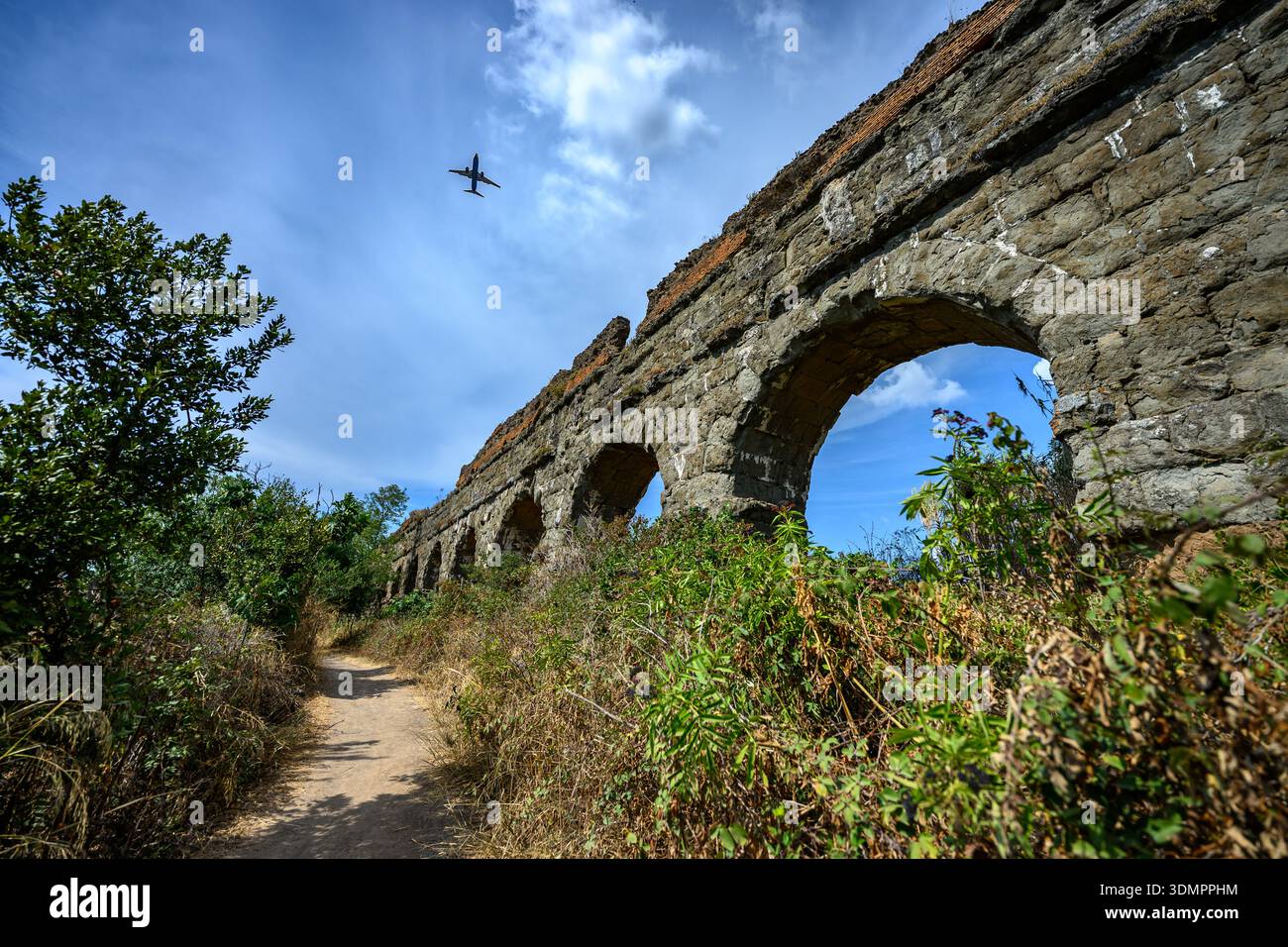 Historische Aquäduktstruktur mit sich wiederholenden Bögen und Mauerwerk im Parco degli Acquedotti Park, Rom. Stockfoto
