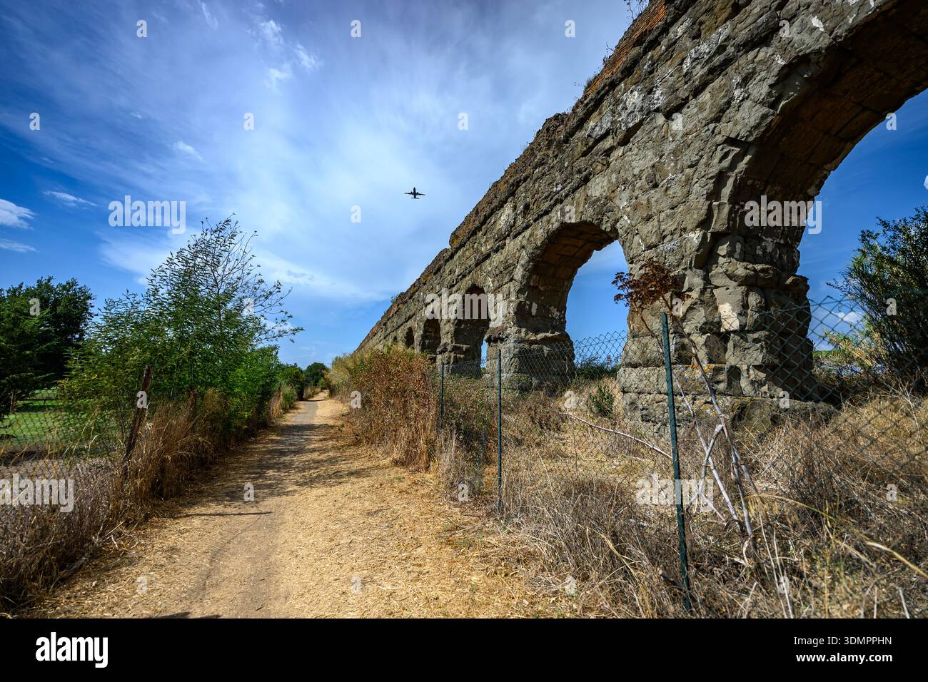 Steinbögen eines antiken römischen Aquädukts stehen auf offenem Gelände im Parco degli Acquedotti, Rom, Italien. Stockfoto