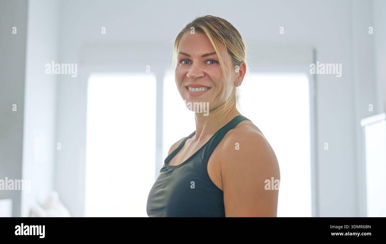 Frau lächelt nach dem Fitnesstraining zu Hause Stockfoto