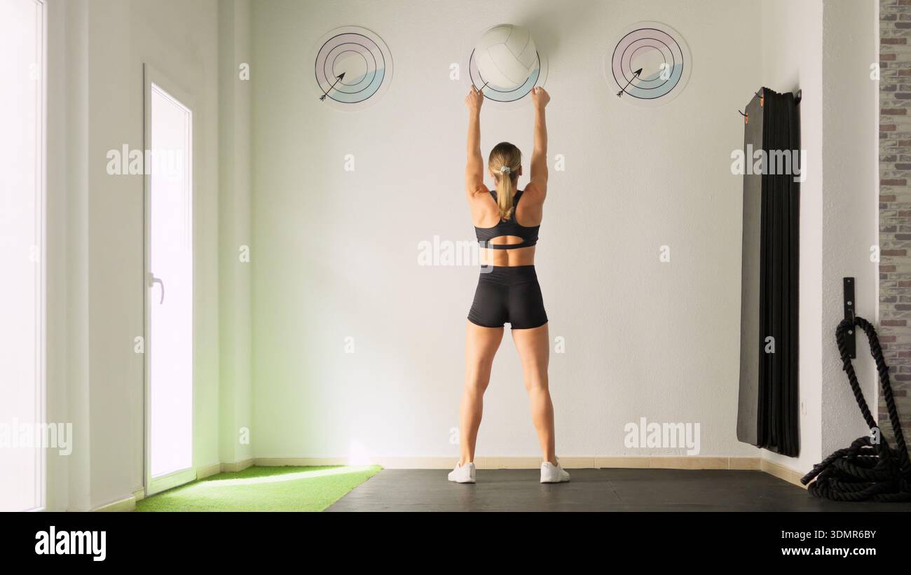 Frau, die mit Medizinball im Fitness-Studio trainiert Stockfoto