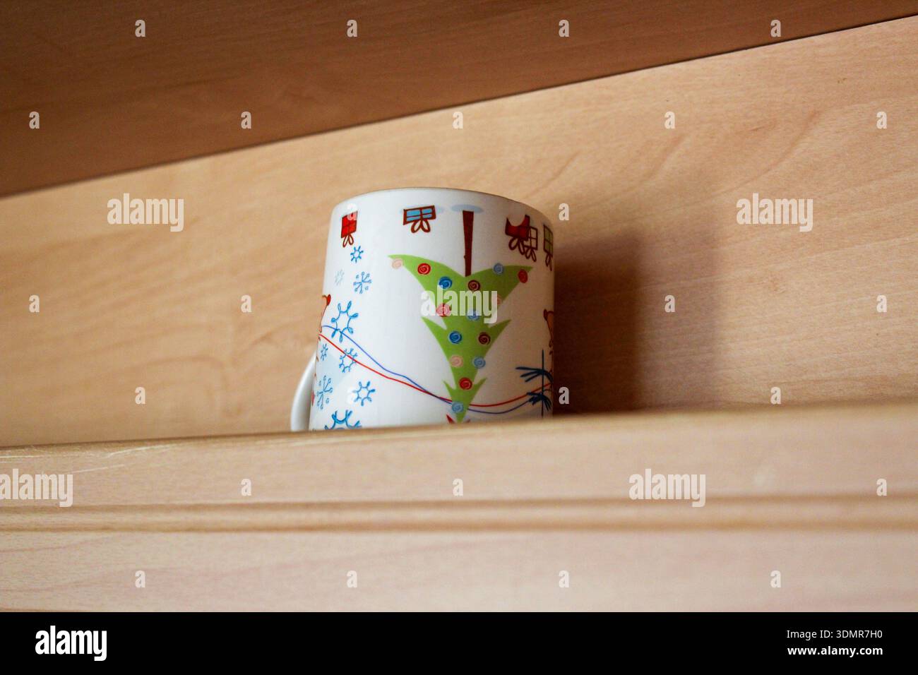 Wunderschöner kleiner Teetasse mit Weihnachtsdruck auf dem Regal. Stockfoto