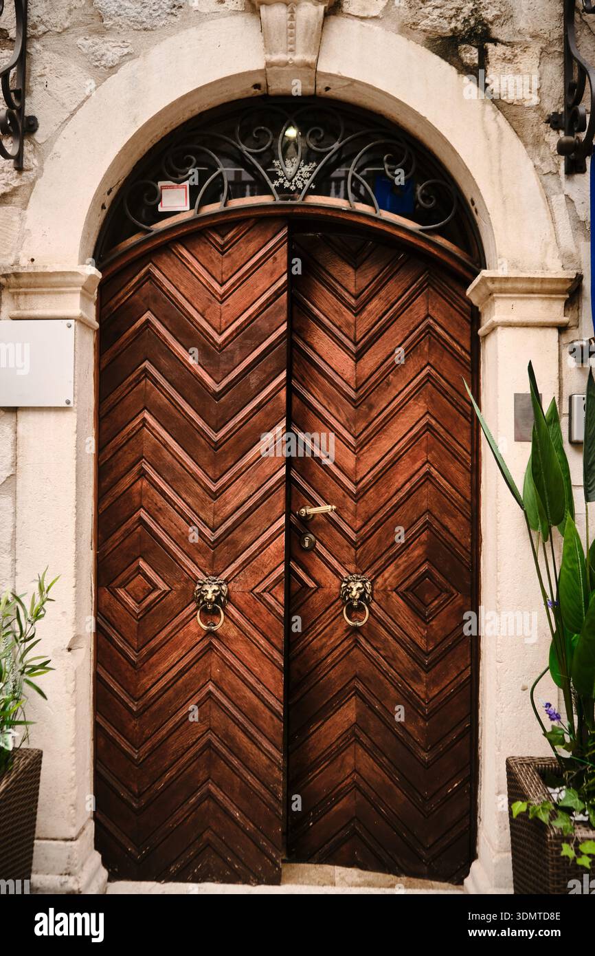 Verzierte Holzbogentür in einem historischen Steingebäude Stockfoto