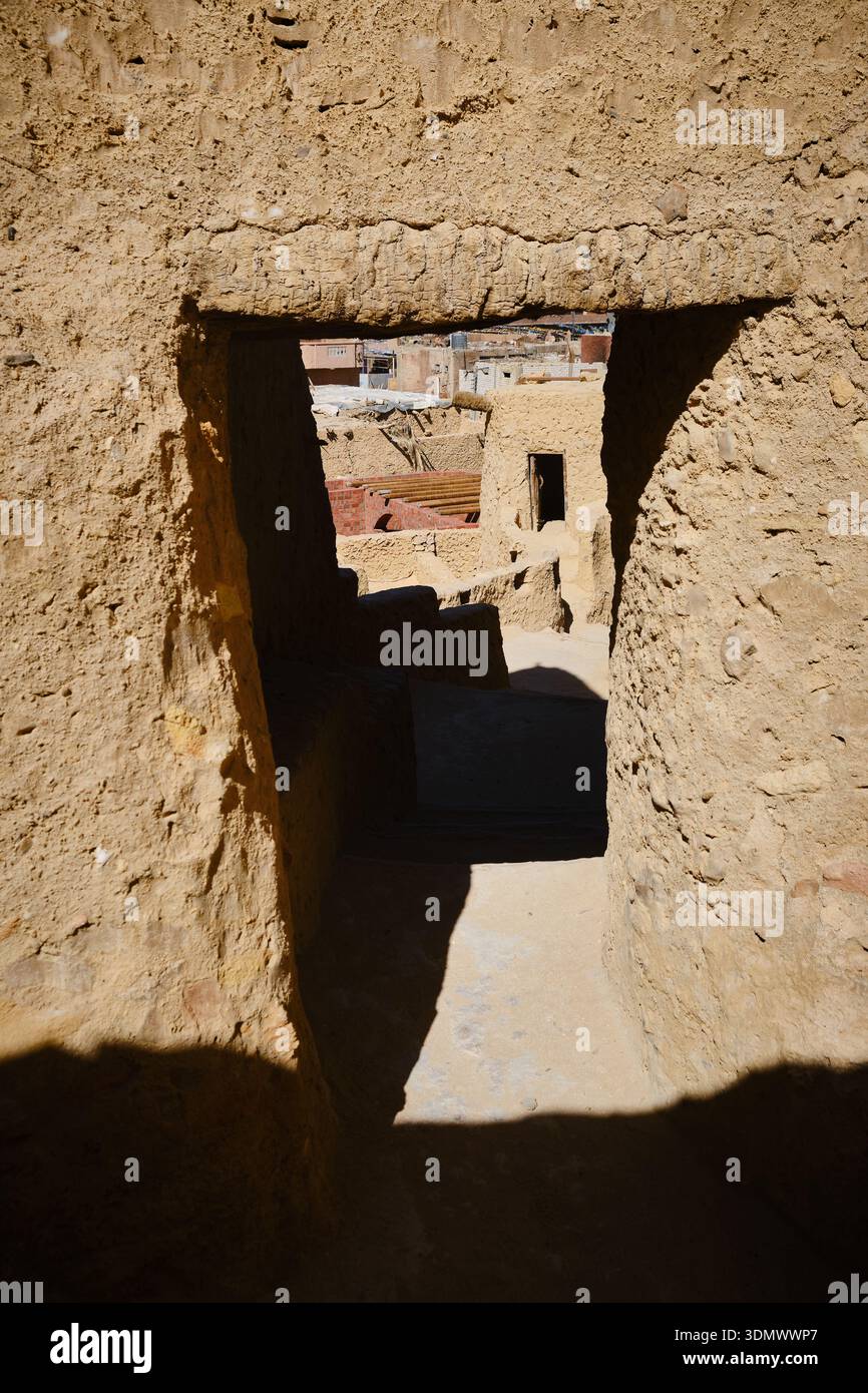 Steintür, die die sonnenbeschienene Wüstensiedlung umrahmt Stockfoto