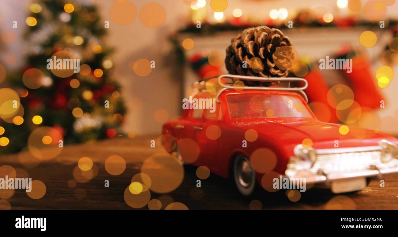 Mit rotem Oldtimerwagen, der auf Holztisch im Wohnzimmer sitzt, mit Dachträger aus Tannenzapfen Stockfoto