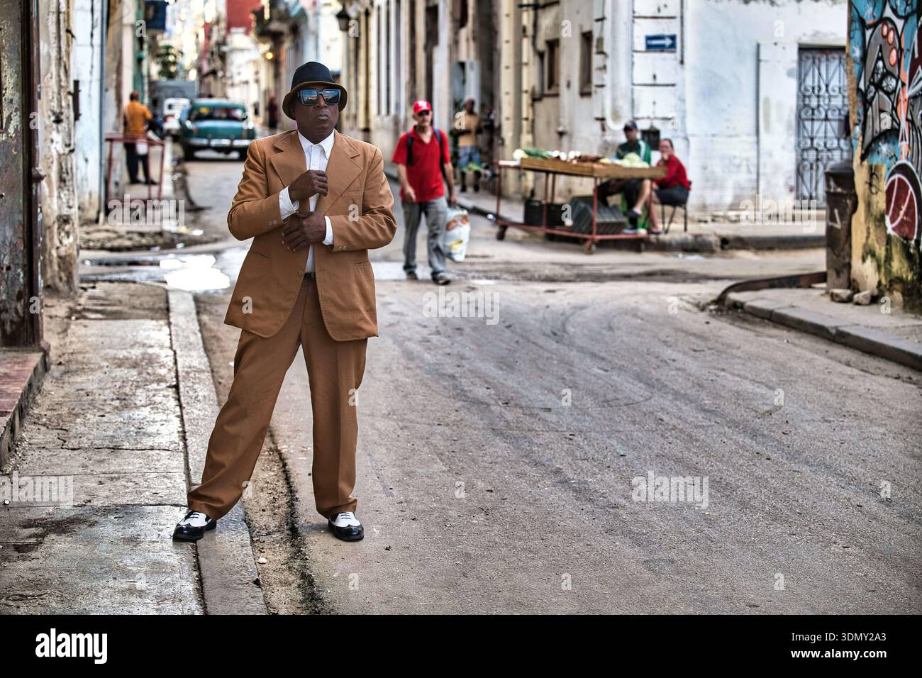 Stilvoll gekleidete Person in der Havana Street mit Verkäufern und Oldtimer Stockfoto