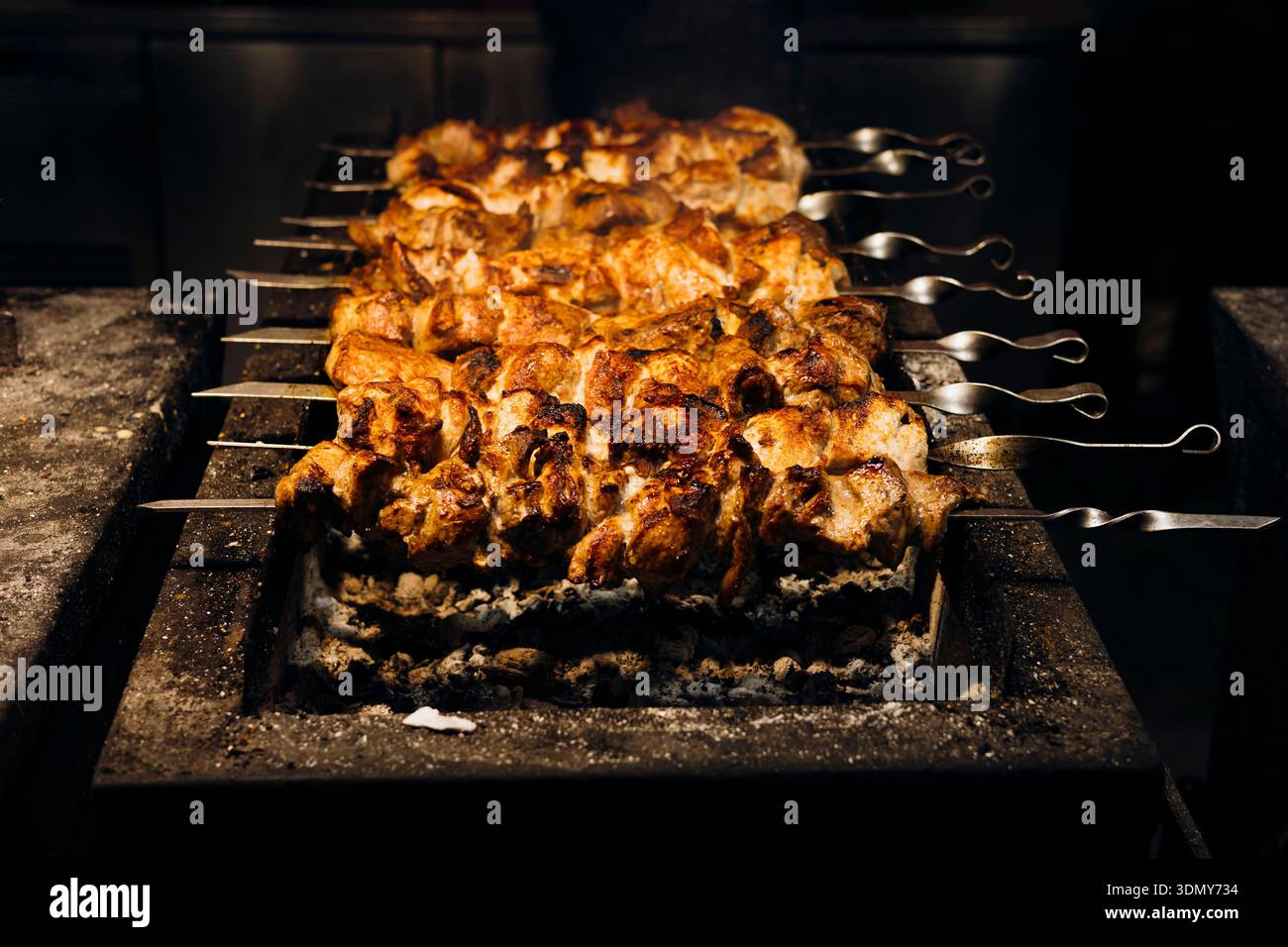 Saftige, gewürzte Fleischspieße werden auf einem belebten Street Food Market perfekt über offener Flamme gegrillt, um die Essenz authentischer Outdoor-Spezialitäten zu erfassen Stockfoto