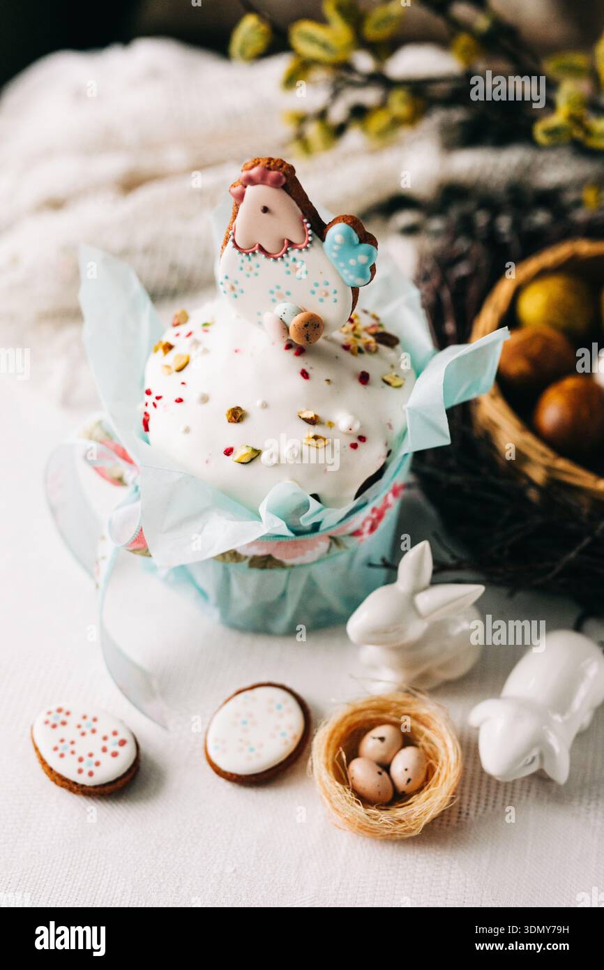 Genießen Sie einen festlichen Osterkuchen, der mit einer entzückenden Glashülle, farbenfrohen Dekorationen und Frühlingsakzenten wie Eiern und bunni geschmückt ist Stockfoto