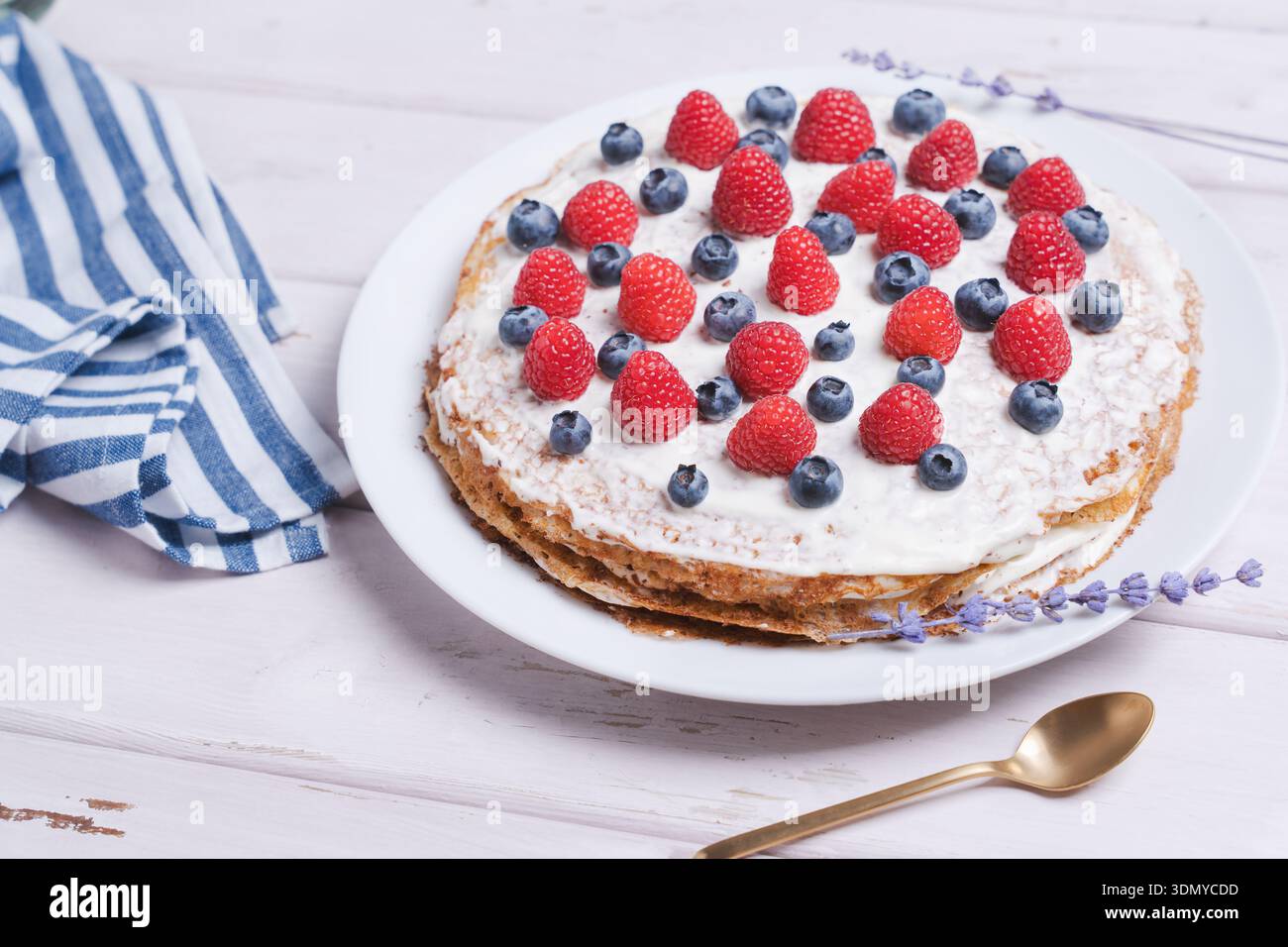 Hausgemachter Kreppkuchen gefüllt mit Sahne und Schokoladenbröseln, garniert mit frischen Beeren, köstliches leichtes Familiendessert Stockfoto