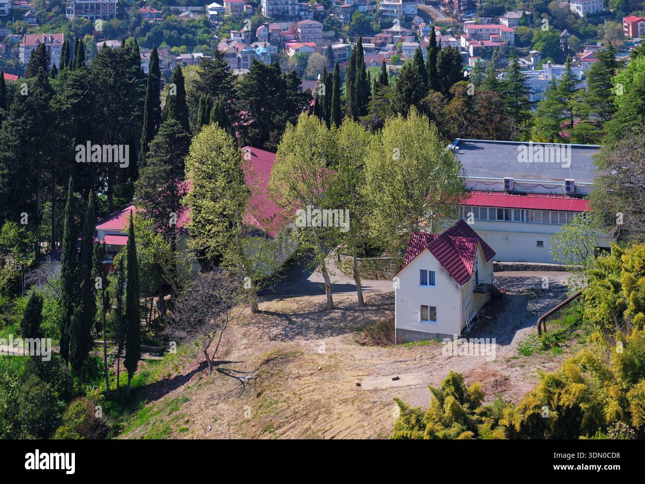 Der Blick von der Aussichtsplattform im oberen Teil des Arboretum Parks auf das freistehende Ferienhaus auf einem Hügel zwischen Wohngebieten von Sotschi. Krasnodar K. Stockfoto
