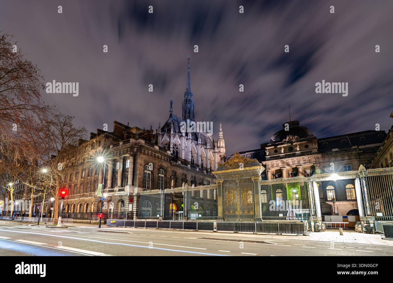 Historisches Eingangstor des Palais de Justice und der Turm der Sainte-Chapelle, beleuchtet bei Nacht auf der Ile de la Cite in Paris, Frankreich Stockfoto