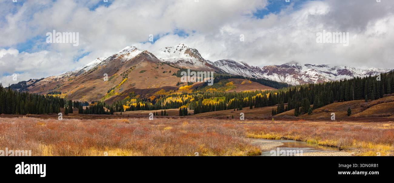 Herbstfarben schmücken das Gothic Valley in der Nähe von Crested Butte, Colorado, während der obere Teil des Mount Belleview und die Elk Range Peaks von frischem Schnee bedeckt sind. Stockfoto