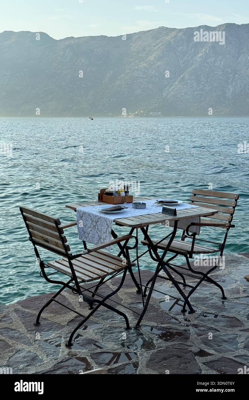 Das Restaurant am Wasser im Dorf Prcanj an der Bucht von Kotor bietet eine dramatische Aussicht, frische Meeresfrüchte und eine Flucht vor den Menschenmassen von Kotor. Stockfoto