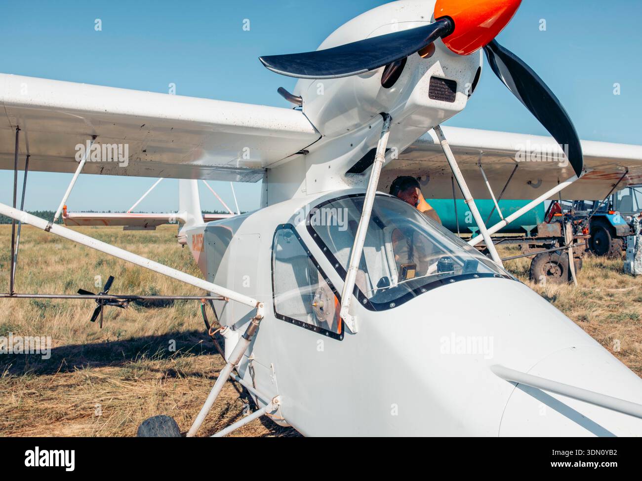 Einmotoriges landwirtschaftliches Flugzeug auf der Landebahn auf dem Lande vor dem Flug mit großem landwirtschaftlichem Hintergrund, Konzept der Landwirtschaft, Luftverkehrsdienste Stockfoto
