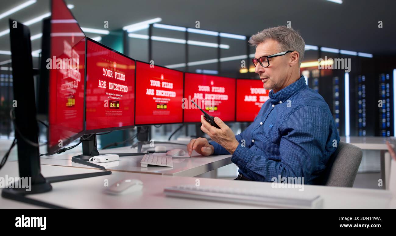 Mann, der den Sicherheitsdienst trägt, überwacht Überwachungskameras im Kontrollraum. Stockfoto