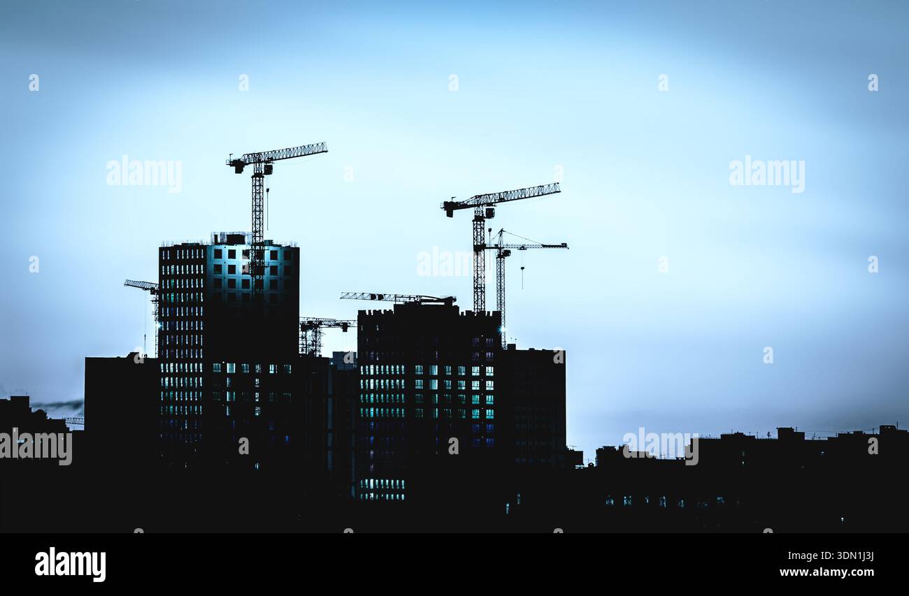 Apartmenttürme auf der Baustelle, blaue Stunden-Silhouetten Stockfoto