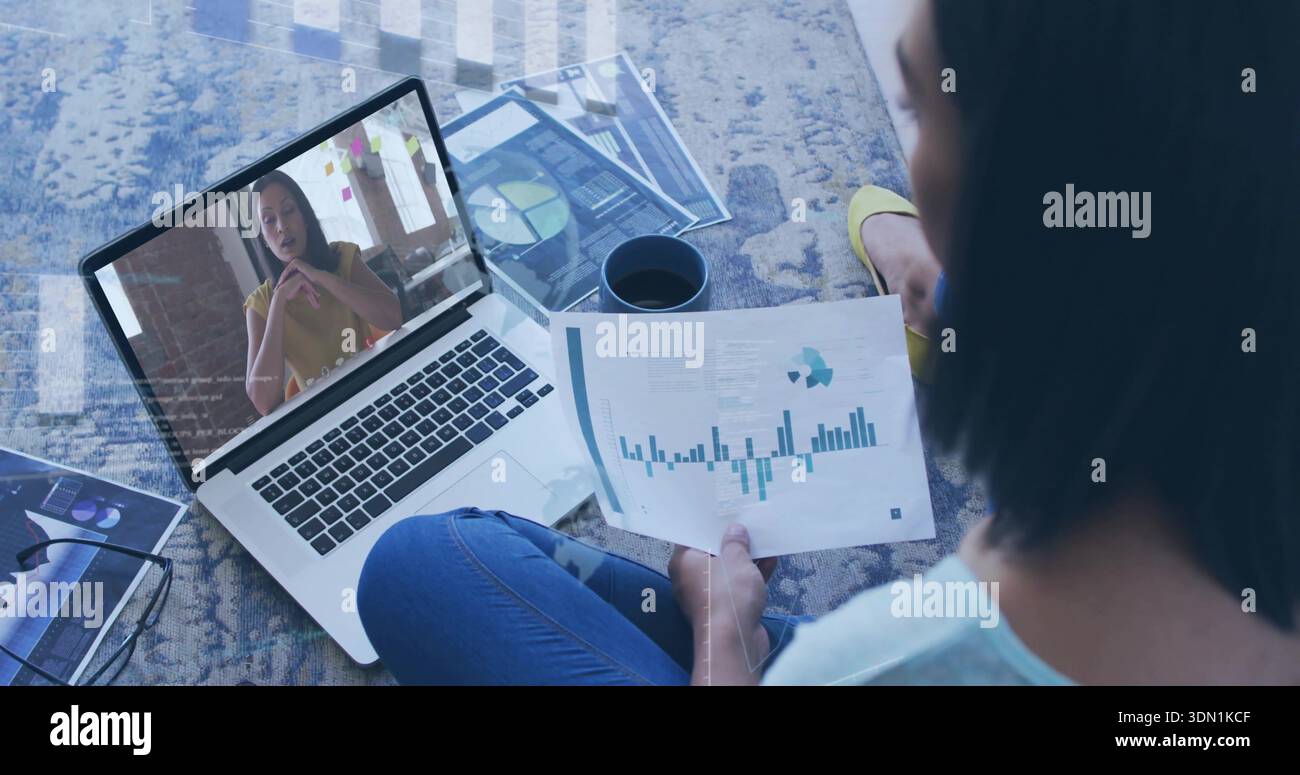 Bericht halten, Frau in blauem Oberteil, Jeans, die Karten zu Hause auf Teppich überprüft, Laptop, Kopierraum Stockfoto