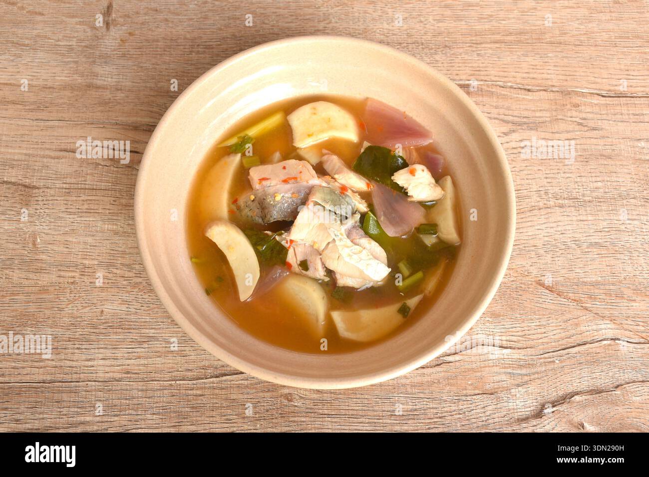 Gekochtes Barschfischfleisch und Pilze in klarer tom Yum Thai-Kräutersuppe auf einer Schüssel Stockfoto