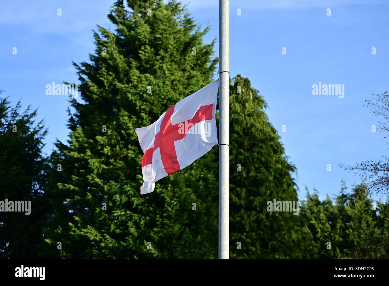England-Flagge am Halbmast vor blauem Himmel Stockfoto