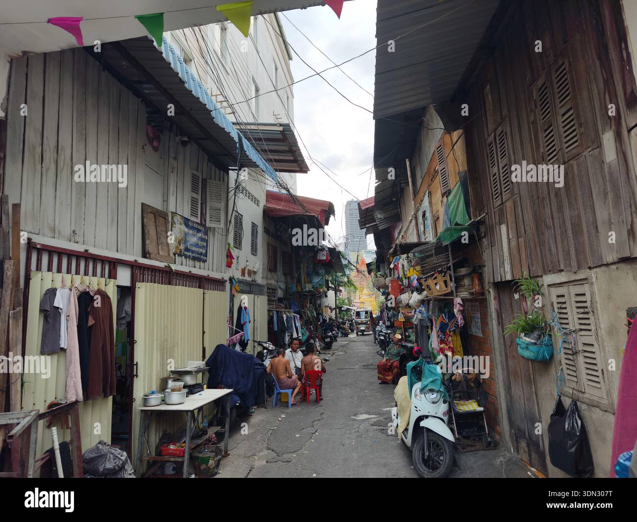 Gasse in der historischen Altstadt von Phnom Penh, geschäftige, alltägliche lokale Umgebung mit Holzläden an beiden Seiten. Kambodscha Stockfoto