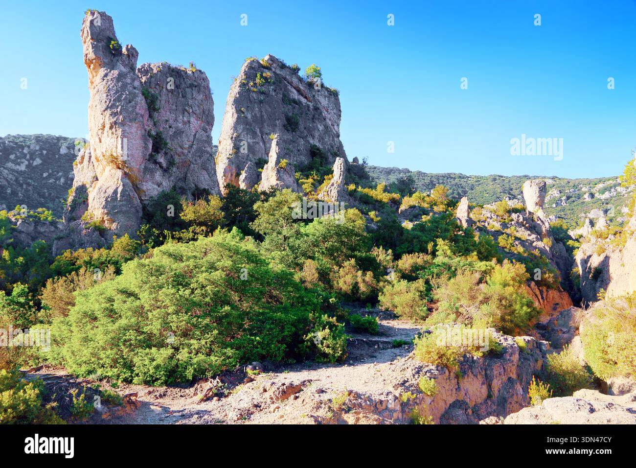 Felsen im malerischen Kessel von Mourèze. Hérault, Frankreich. Dolomitischer Kalkstein erodiert zu einer charakteristischen Form von Ruinen in der Natur. Stockfoto