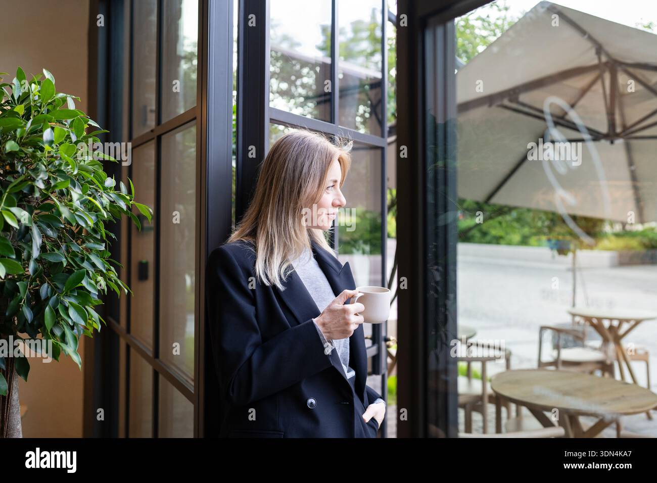 Eine durchdachte Geschäftsfrau, die gerne Kaffee trinkt und neue Karriereziele plant. Stockfoto