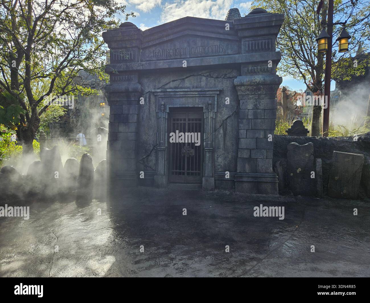 EDITORIAL USE ONLY-ORLANDO, FLORIDA- Januar 2026: Der unheimliche, nebelbehüllte Eingang zu den Frankenstein-Katakomben im Darkmoor Village am Universal Epic Universe. Das Mausoleum aus Stein ist mit der Inschrift „Frankenstein Catacombs“, rostigen Eisentoren und realistischen verwitterten Rissen versehen. Dicker atmosphärischer Nebel rollt über den Boden, beleuchtet von natürlichem Sonnenlicht, und schafft eine gruselige, immersive Szene im Dark Universe Themengebiet des Universal Orlando Resort. Stockfoto