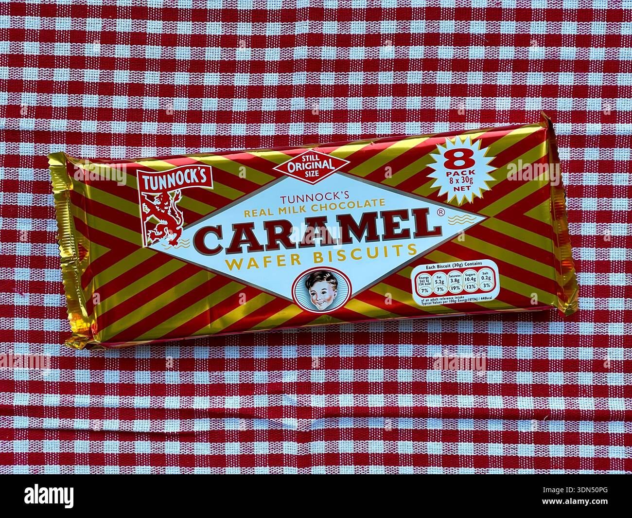 Eine Packung schottischer Tunnock's Caramel Wafer-Kekse auf einer rotem Karo-Tischdecke, ikonische echte Milchschokolade-Kekse aus Schottland - Smartphone-aufgenommenes Stockfoto