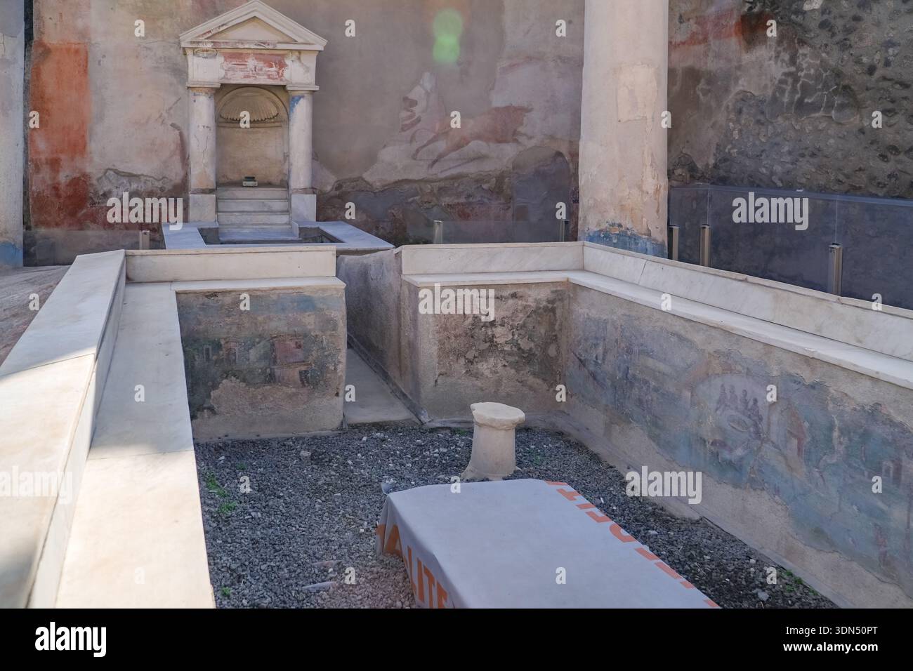 Haus des Ephebus, Domus des Ephebus. Ruinen in Pompeji, Italien, mit einer kleinen Schrein-Nische (Lararium) und verblassten römischen Wandmalereien. Stockfoto