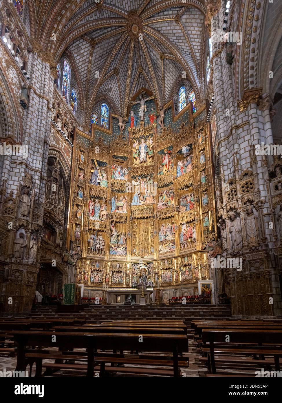 Toledo, Spanien - 26. Juli 23: Großer vergoldeter Hauptaltar der Kathedrale von Toledo, eingerahmt von gotischen Gewölben und Buntglaslicht in Toledo, Spanien. Stockfoto