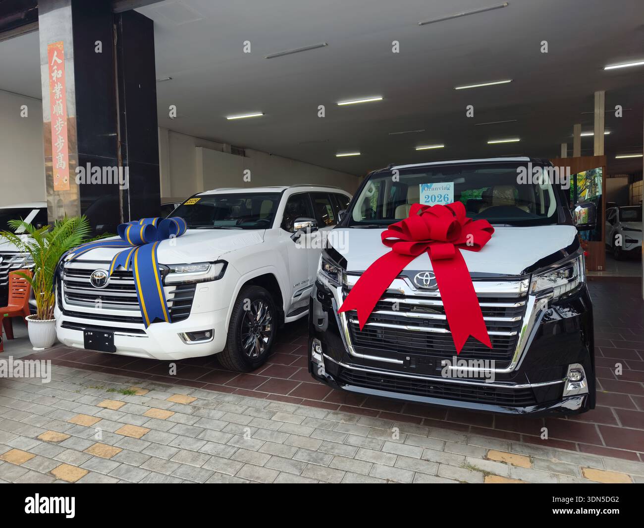 Zwei neue Toyota-Fahrzeuge: Ein Land Cruiser VXR/ZX SUV auf der linken Seite und ein Hiace Super Grandia Elite Van auf der rechten Seite. Händler in Phnom Penh Kambodscha Stockfoto