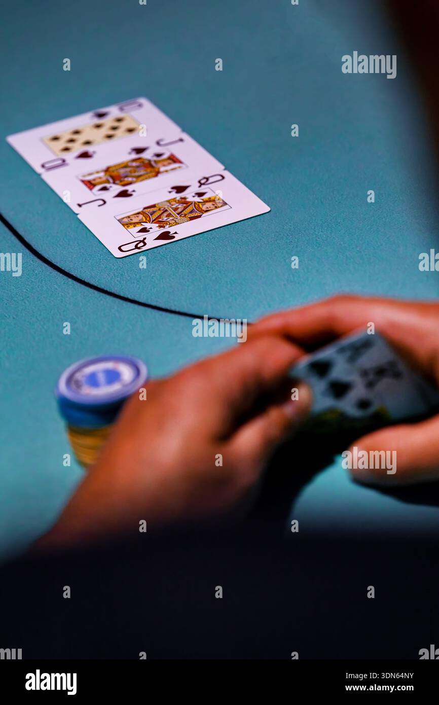 Nahaufnahme eines Mannes, der Texas Hold'em Poker spielt und einen Royal Flush floppt, die höchstmögliche Hand Stockfoto