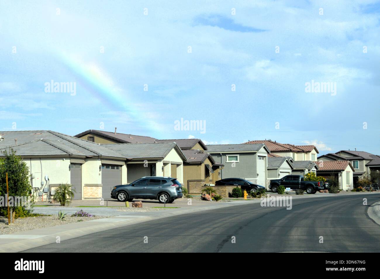 Moderne Häuser in der Nachbarschaft in Maricopa, Arizona mit Rainbow over Desert Vorort Stockfoto