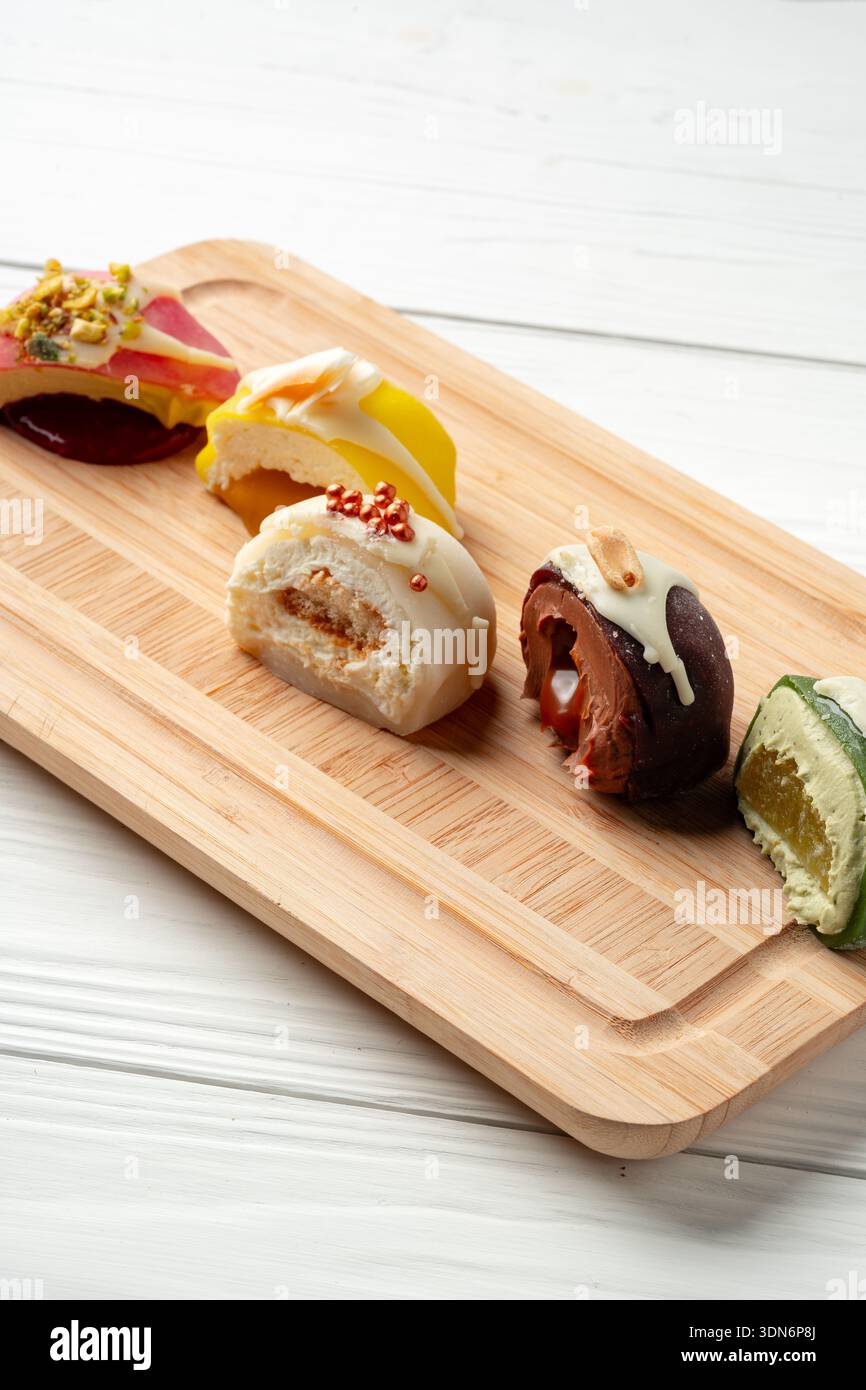 Verschiedene Süßigkeiten werden auf einem Holzbrett in einem Dessertgeschäft ausgestellt Stockfoto