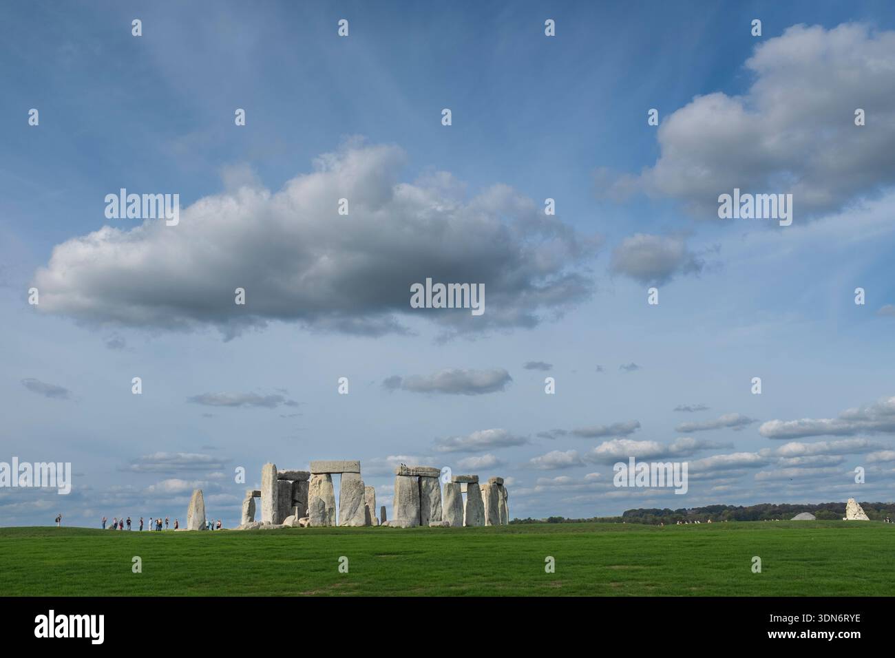 Stonehenge berühmtes englisches altes Wahrzeichen in einem grünen Feld unter einem wunderschönen blauen Wolkenhimmel in den Cotswolds Stockfoto