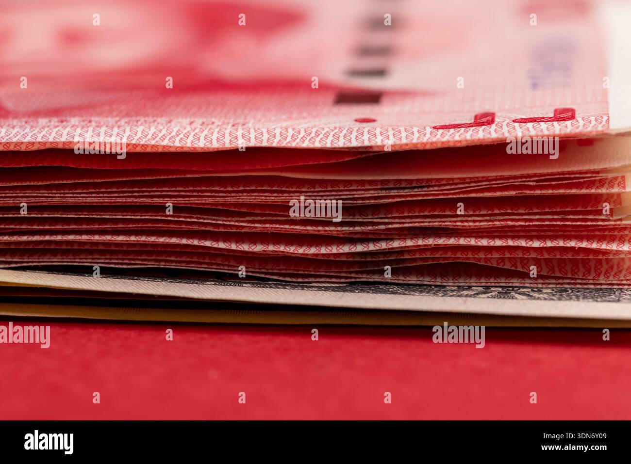 Ein Stapel Papiergeld mit amerikanischem und chinesischem Geld, chinesische Banknoten von 100 Yuan, Nahaufnahme Stockfoto