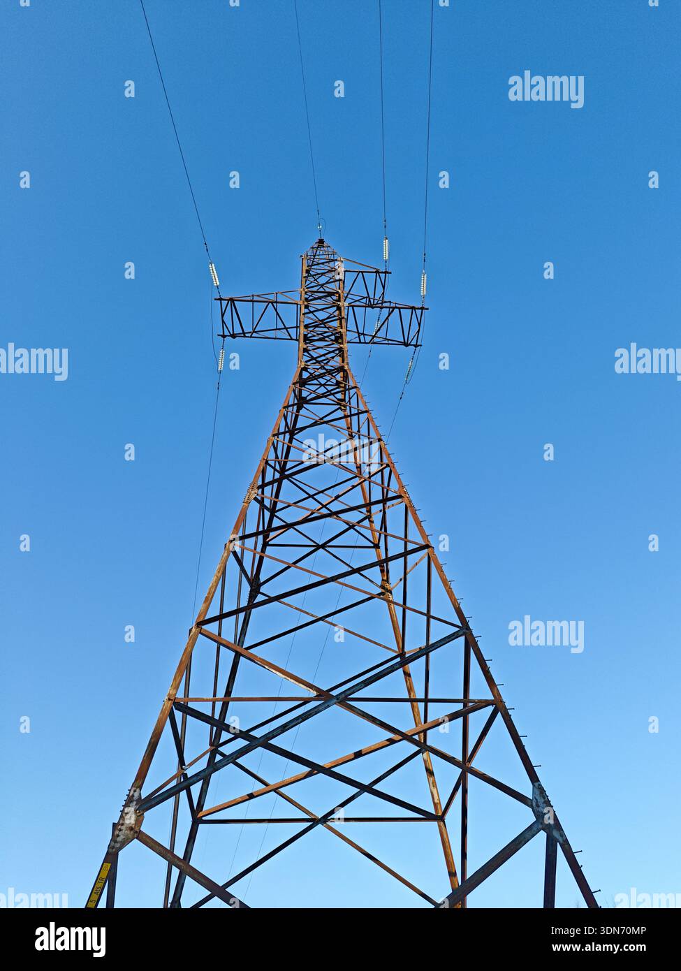 Hochspannungs-Pylonturm gegen einen klaren blauen Himmel Stockfoto