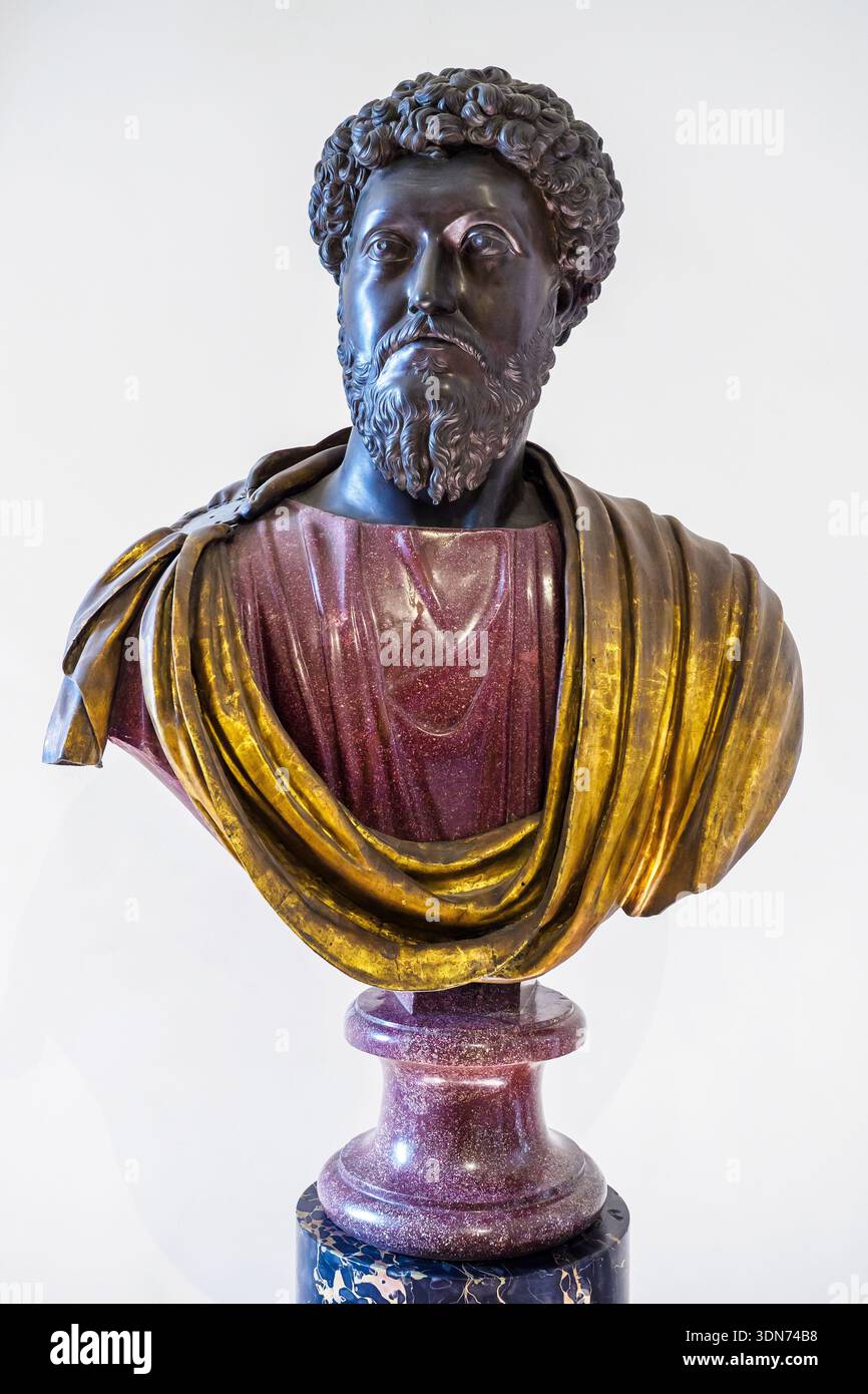 Büste von Marcus Aurelius (121 n. Chr.–180 n. Chr.) römischer Kaiser von 161 bis 180 n. Chr. - Kopf, Hals und vergoldeter Bronzemand, Büste in altem rotem Porphyr - der Bronzekopf ist eine Kopie aus dem 17. Jahrhundert, die von der berühmten Reiterstatue von Marcus Aurelius auf dem Kapitolshügel abgeleitet wurde, eingefügt wurde, um eine alte rote Porphyrbüste aus der ersten Hälfte des 4. Der kurze vergoldete Bronzemäntel ist auch auf eine moderne Restaurierung zurückzuführen - Palazzo Altemps, Museo Nazionale Romano - Rom, Italien Stockfoto