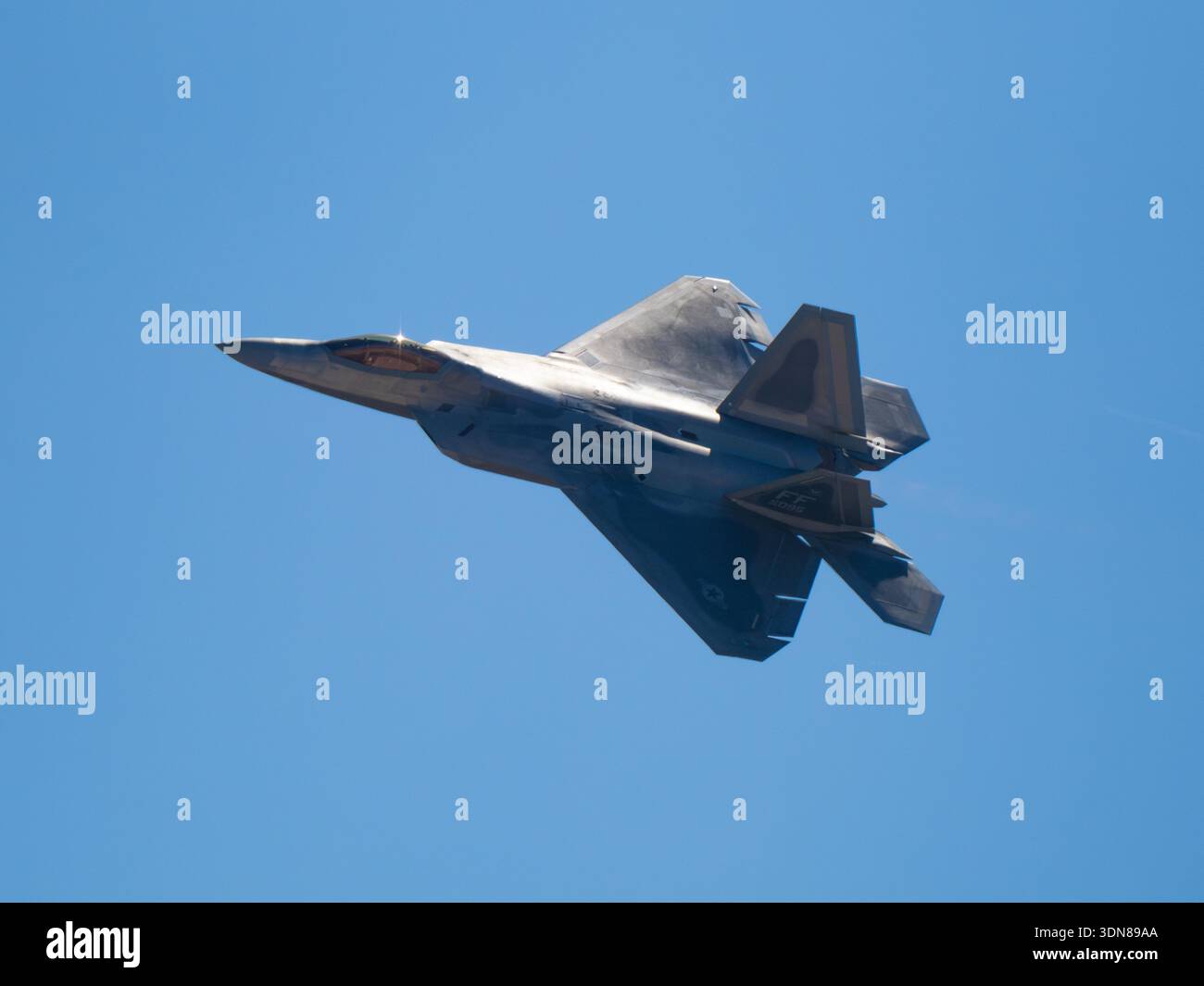 San Diego, Kalifornien, USA – 28. September 2025: Ein F-22 Raptor der US Air Force führt eine Bankenkurve durch und enthüllt das Tarnmuster und die geometrische Struktur Stockfoto