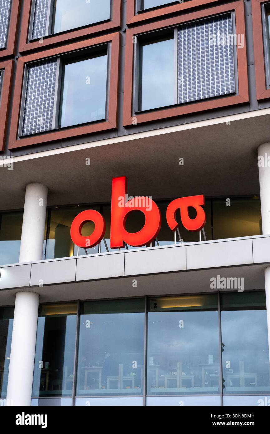 Außenansicht der Fassade der öffentlichen Bibliothek OBA Centrale mit dem roten oba-Schild und den Solarpaneelen für Fenster, Amsterdam, Noord-Holland, Niederlande, Stockfoto