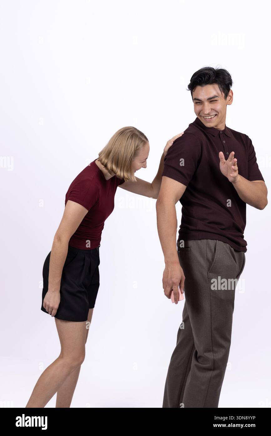 Frau lehnt sich auf den Mann zurück, während sie im Studio redet Stockfoto