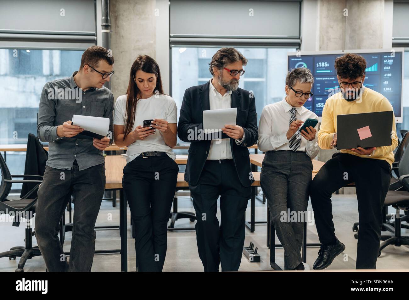 Vielfältige Gruppe von Geschäftsleuten in einem modernen Büro, die mit digitalen Geräten zusammenarbeiten und interagieren, Teamarbeit, Innovation, Stockfoto