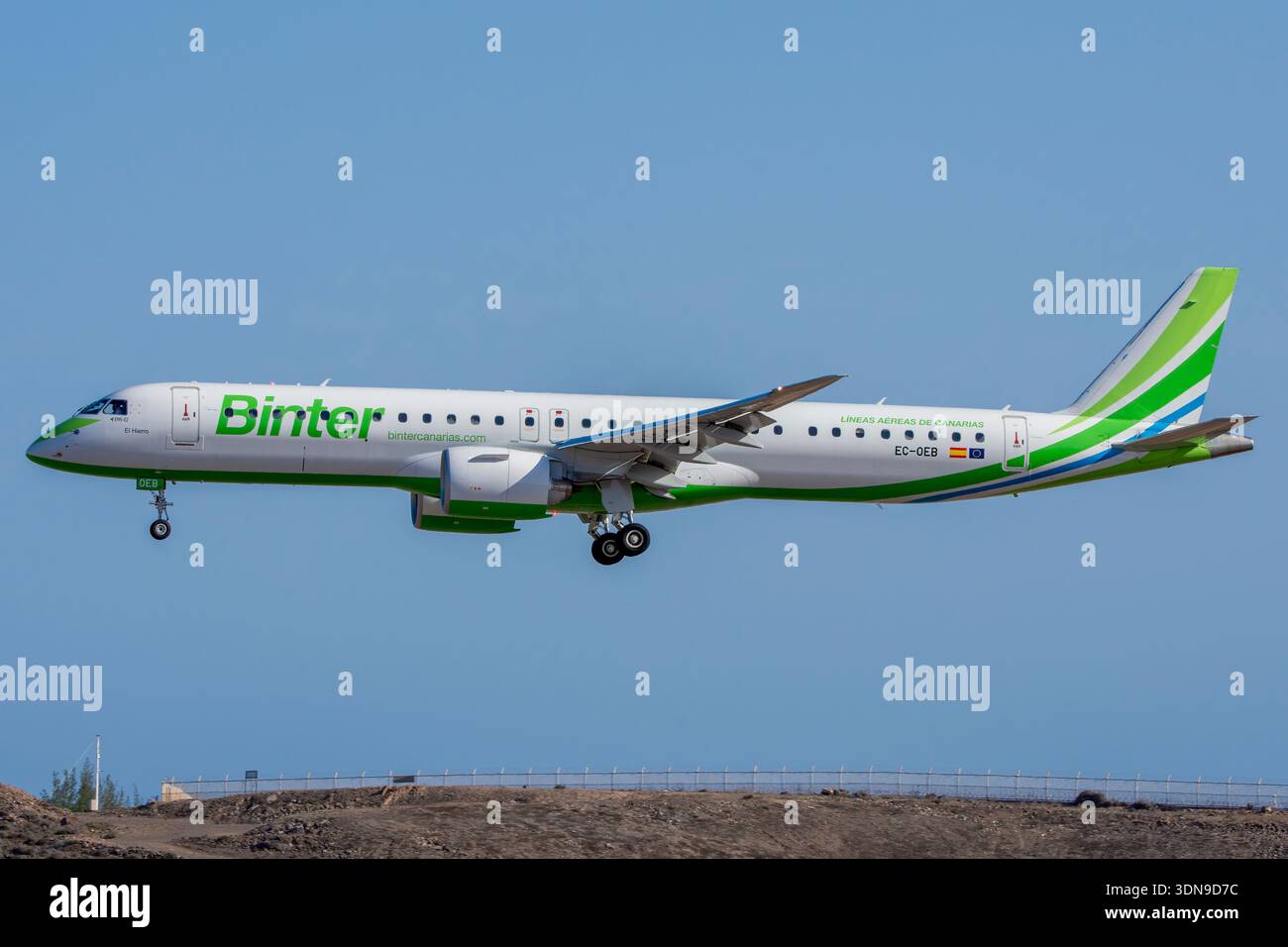 Binter Canarias Embraer E195-E2-Passagierflugzeug (Kennzeichen EC-OEB) fliegt in niedriger Höhe im Endanflug mit ausgefahrenem Fahrwerk vor einem klaren Himmel. Stockfoto