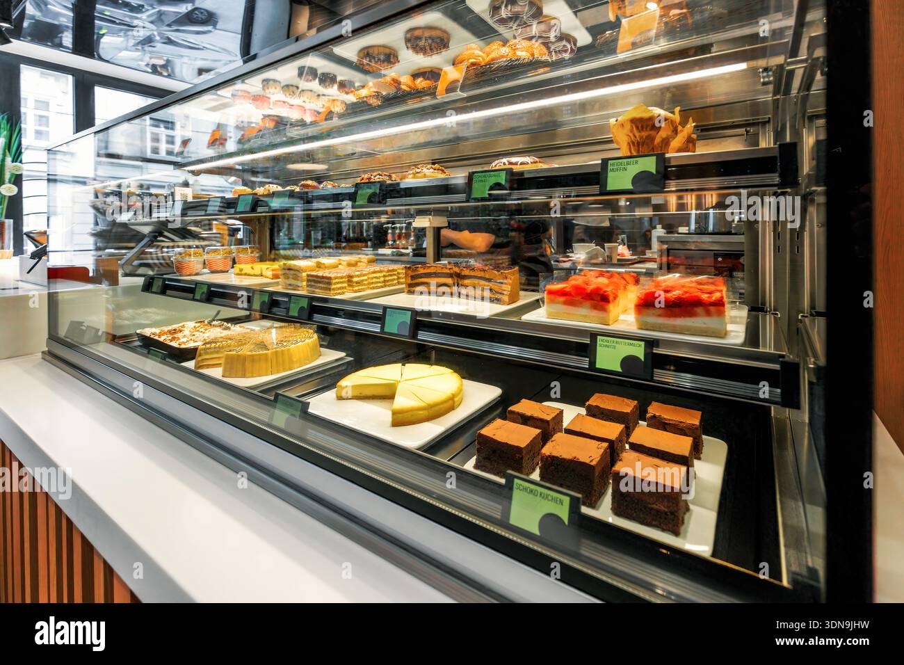 Dessertpräsentation mit einer lebhaften Auswahl an Kuchen, Muffins und Gebäck in einem Café in Wien, Österreich. Stockfoto